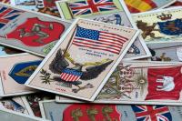 A close-up of a selection of cigarette cards relating to flags and nations.